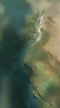 An aerial view showcases a serpentine river winding through green wetlands and arid desert landscapes, showing the stark contrast between nature elements.