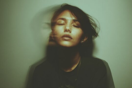 Abstract portrait of Asian woman with closed eyes against muted green wall, double exposure effect, dark hair, peaceful