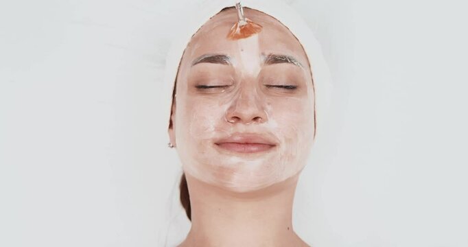 A woman enjoys a facial at a beauty salon or spa. The concept of cosmetology and spa.