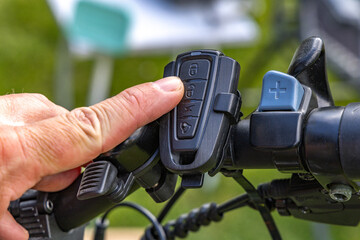 Cyclist turns on the alarm on the bike, activating the anti-theft protection using the remote control on the handlebar