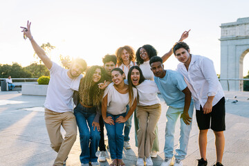 Obraz premium Cheerful young students posing together outdoors, enjoying laughter and friendship while capturing joyful moments in the summer sunlight