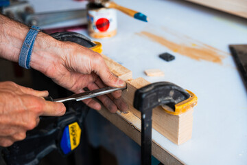 Carpintero devastando madera en taller de carpintería con herramientas