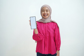 Confident Young Asian Muslin Woman in Hijab Showing Smartphone with Blank Screen on Isolated...