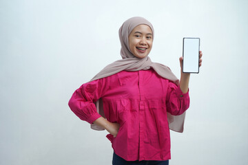 Confident Young Asian Muslin Woman in Hijab Showing Smartphone with Blank Screen on Isolated...