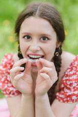 Dental care. Smiling girl putting on aligners. Plastic retainers for teeth alignment.