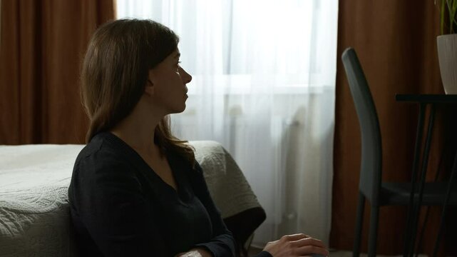 Portrait of lonely and sad woman sitting in the room. Concept of female depression and problems. Mental health, stress.