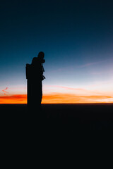 Silueta de hombre en la cima de la montaña al amanecer