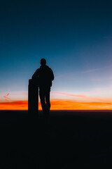 Silueta de hombre en la cima de la montaña al amanecer