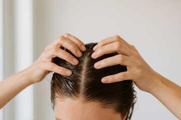 Naklejka premium Hair Care Ritual: A close-up shot highlights the meticulous care as hands gently massage hair, with a sense of well-being.