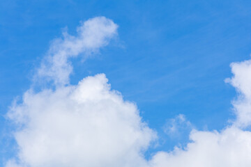 Bright blue sky with fluffy white clouds.