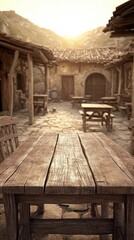Naklejka premium Rustic wooden table overlooking a sun-drenched, historic courtyard with stone buildings and paving. Warm, vintage aesthetic