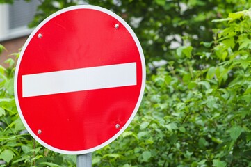 No entry sign prohibiting access with green foliage background