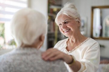 Female home caregiver providing emotional support to an elderly woman
