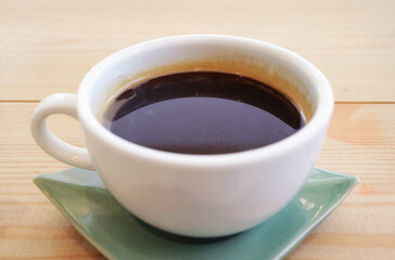 Closeup of aromatic hot coffee isolated on wooden table