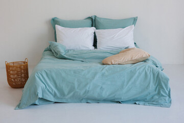 In a cozy bedroom, there is a bed adorned with a soft blue comforter and neatly arranged white pillows, creating an inviting atmosphere for rest