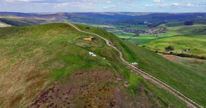 Established aerial video of hikers going up a path to the top of Mam Tor peak in Peak District - UK 