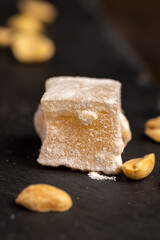 Turkish delight with peanuts, scattered oriental sweets Turkish delight with peanuts on a board, close up