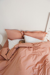 A woman is peacefully sleeping in a cozy bed adorned with soft pink sheets and fluffy white pillows, creating a serene atmosphere