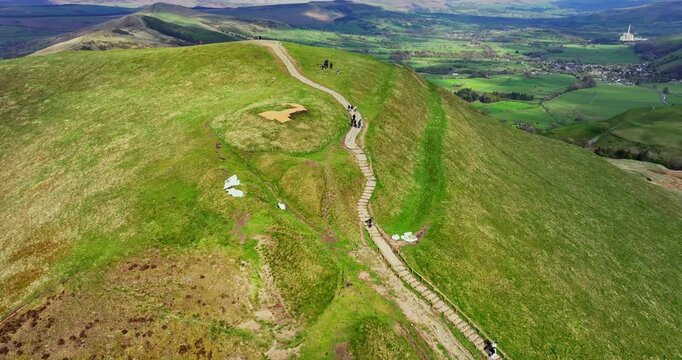 Established aerial video of hikers on a path that leads to the top of Mam Tor peak in Peak District - UK