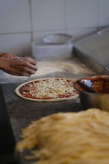 Pepperoni pizza in preparation on a floured countertop