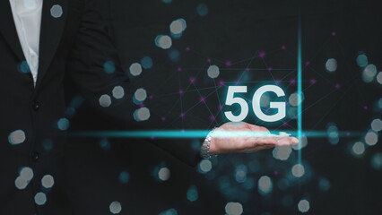 Businessman holding glowing 5G network icon. Concept of high-speed technology, innovation, connectivity, and futuristic wireless communication in modern digital transformation.