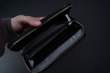 A hand hold an open old empty wallet,black background