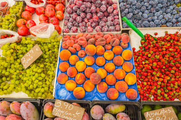 Fresh organic fruits and berries on farmers market stall close up.