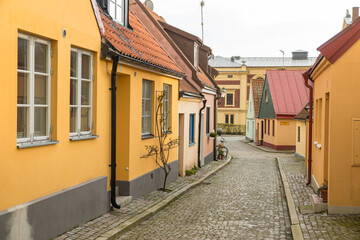 Colorful small houses along cobbled street in Ystad, Sweden.