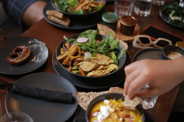 Greek Salad with Croutons on Plate Surrounded by Glasses and Other Dishes