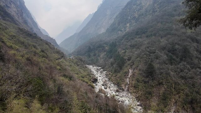 4k video footage of Himalayan mountains valley with forest and Modi River or Modi Khola, foggy and misty weather seen afar.