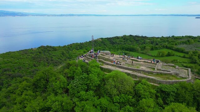 Orbiting aerial footage of the historic Rocca di Manerba fortress overlooking Lake Garda, Italy