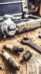 Automotive tools and spark plugs on a rustic wooden surface convey repair, maintenance, and vintage charm. Perfect for DIY, garage, or industry concepts.