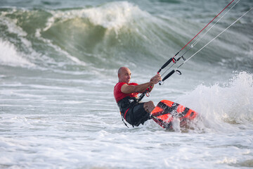 Naklejka premium extreme kitesurfer riding a kite on the waves in the sea