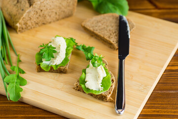 Vegetarian snack with cheese spread and fresh leaves