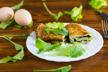 Healthy egg roll with greens on a white plate