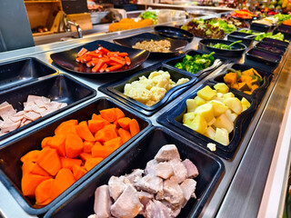 A salad bar featuring an extensive variety of fresh vegetables and fruits