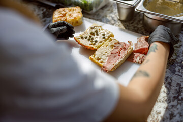 A skilled chef meticulously prepares artisanal sandwiches using fresh, highquality ingredients for...