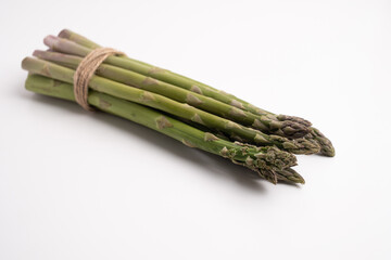 Green asparagus on a light background. Bunch of ripe fresh asparagus. Healthy organic food. Cook at home. Natural vitamins, raw materials for food. Handpicked Bio Asparagus