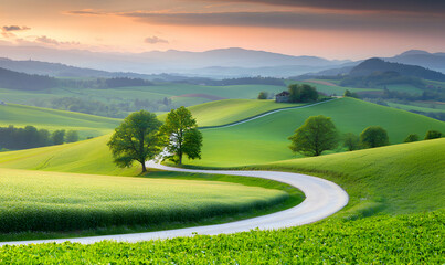 Fototapeta premium Scenic view with winding road through green fields and trees, under a warm, peaceful sky