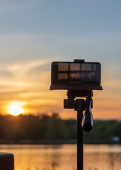 Cell phone on the tripod capturing sun set moment. Technology
