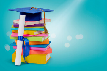 Stack of colorful books in multi-colored covers with elementary graduate cap on top. Reading...
