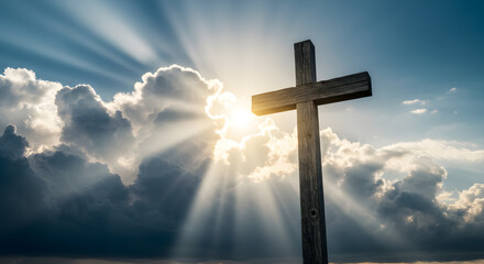 Wooden cross against a dramatic sky with sun rays piercing through the clouds, symbolizing faith and hope with its serene representation.