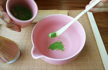Scooping Matcha Tea Powder with Bamboo Tea Scoop Called CHASHAKU for Making Green Tea