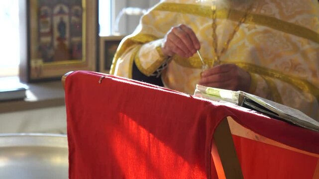 A priest of a Christian church consecrates the water in the baptismal font to perform the rite of baptism