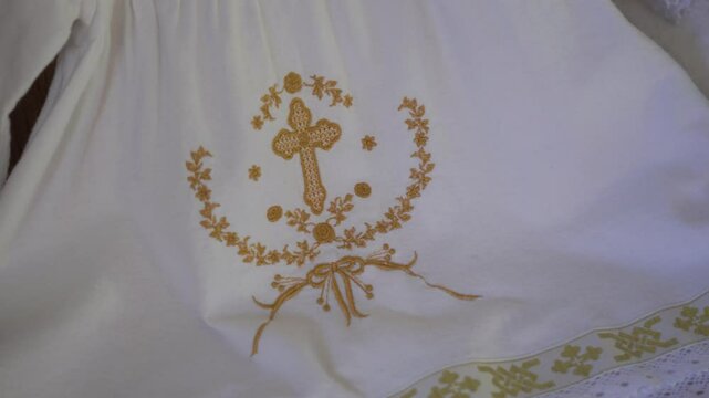 a special white blanket with the symbol of Christianity for a child during the baptism ceremony