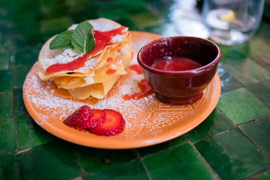 Dessert Milfey. Strips of puff pastry with curd cream strawberry berries. On a dark green background