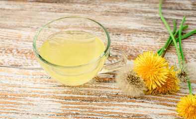 Dandelion tea in a transparent cup. Healthy herbal tea.