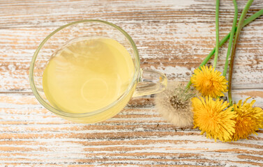 Dandelion tea in a transparent cup. Healthy herbal tea.