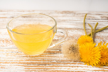 Dandelion tea in a transparent cup. Healthy herbal tea.