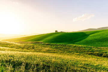 scenery rural view of a contryside farm in green fields and hills with amazing cloudy sky on background